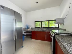 eine Küche mit einem Kühlschrank aus Edelstahl und roten Schränken in der Unterkunft Casa Dzitya in Mérida
