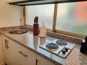a kitchen counter with a stove and a sink at Apartamento con terraza privada junto al Bulevar del Rio in Cali +33 photos
