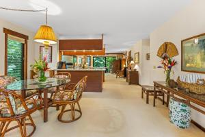 a kitchen and living room with a glass table and chairs at Waikomo Stream Villas 503 in Koloa