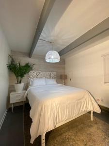 ein Schlafzimmer mit einem weißen Bett und einer Topfpflanze in der Unterkunft 10 guest Ski Chalet Pools Golf Ski Hike in Vernon Township