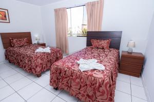 a hotel room with two beds and a window at Hotel Residencial C´BASTIAN in Tacna