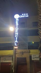a neon sign on the side of a building at Hotel Residencial C´BASTIAN in Tacna