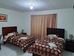 a bedroom with two beds and a window at Hotel Residencial C´BASTIAN in Tacna