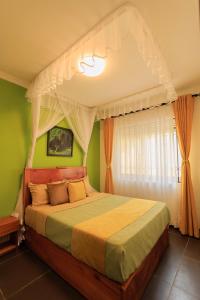 1 dormitorio con 1 cama con dosel en Lucian Cottages en Munyonyo