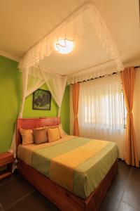 1 dormitorio con 1 cama con dosel en Lucian Cottages en Munyonyo