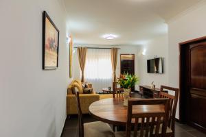 uma sala de estar com uma mesa e uma sala de jantar em Lucian Cottages em Munyonyo