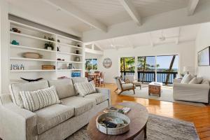 uma sala de estar com um sofá e uma mesa em Kauai Bay House, Ocean Front em Koloa