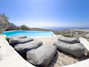 un grupo de pufs sentados junto a una piscina en Villa Prive 88 Mykonos, en Fanari
