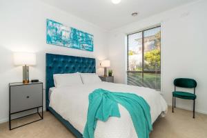 a bedroom with a large bed with a blue headboard at Dromana Premium Retreat - Stunning views in Dromana