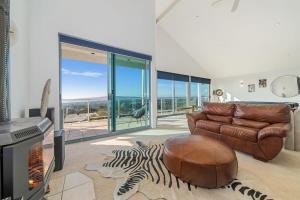 a living room with a leather couch and a zebra rug at Dromana Premium Retreat - Stunning views in Dromana