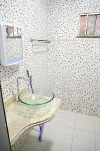 y baño con ducha con lavamanos de cristal. en Boa vista, Hotel Jardim Tropical, en Boa Vista