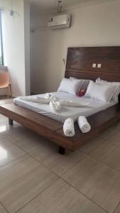 a large wooden bed with three towels on it at Appartement Jully/Plage in Kribi