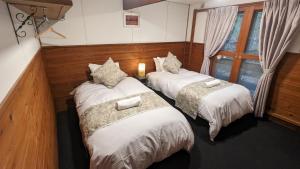 two twin beds in a room with a window at The Jungle House - Hakuba in Hakuba