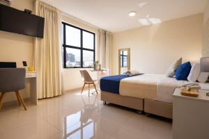 um quarto com uma cama, uma secretária e uma mesa em Rits Apart Hotel em Lima