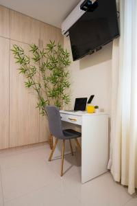 a desk with a laptop and a chair in a room at Rits Apart Hotel in Lima