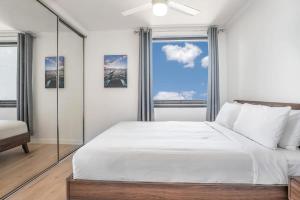 a bedroom with a large white bed and a window at Stylish Central City Retreat with Pool & Parking in Brisbane