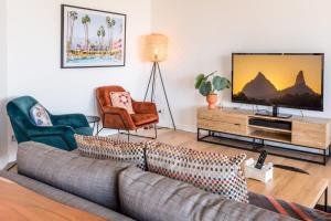 a living room with a couch and two chairs and a television at Stylish Central City Retreat with Pool & Parking in Brisbane