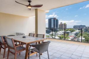 a dining room with a table and chairs on a balcony at Stylish Central City Retreat with Pool & Parking in Brisbane