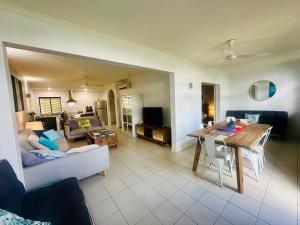 Appartment in Palm Cove في بالم كوف: غرفة معيشة مع أريكة وطاولة طعام