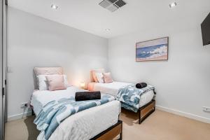 1 dormitorio con 2 camas y TV. en Luxury Breeze Beachfront Apartment, en Victor Harbor