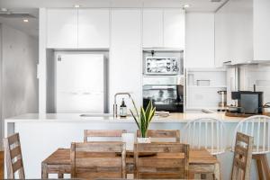 a kitchen with a table and chairs and a counter at Luxury Breeze Beachfront Apartment in Victor Harbor +24 photos