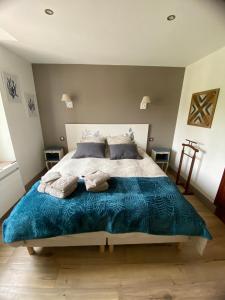 ein Schlafzimmer mit einem großen Bett mit einer blauen Decke in der Unterkunft La Villa Mirabelle 2min d'Arromanches-les-Bains in Tracy-sur-Mer