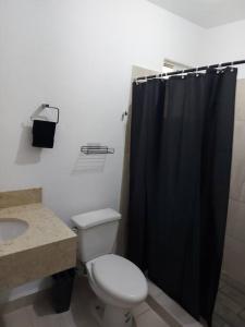 a bathroom with a toilet and a black shower curtain at Alojamiento Entero Monterrey Airport in Monterrey