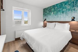 a bedroom with a large white bed and a window at Uptown Inn by Vantaggio Suites in San Diego