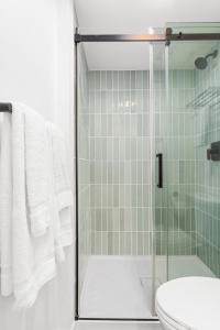 Uptown Inn by Vantaggio Suites في سان دييغو: حمام مع دش مع مرحاض ومغسلة