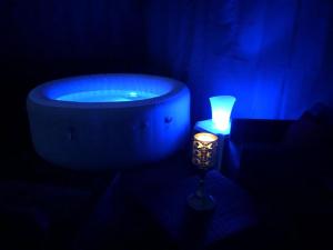 ein Badezimmer mit einer Badewanne, einer Kerze und einem blauen Licht in der Unterkunft Hakuna Matata in Cano