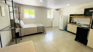 a room with a bed and a kitchen with a refrigerator at Ariana Apart Hotel Canasvieiras in Florianópolis