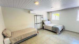 a bedroom with two beds and a window at Ariana Apart Hotel Canasvieiras in Florianópolis