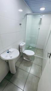 a bathroom with a toilet and a sink and a shower at Ariana Apart Hotel Canasvieiras in Florianópolis