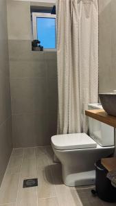 een badkamer met een wit toilet en een raam bij Wabi Sabi in Katastárion