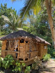 uma pequena cabana com telhado de palha e palmeiras em Eco Park - Albur Rental Properties em Alburquerque