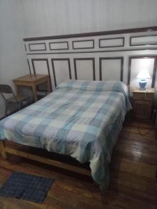 una camera con un letto e un piumone blu e bianco di Habitac Indiv Casa de Familia, Flores a Buenos Aires