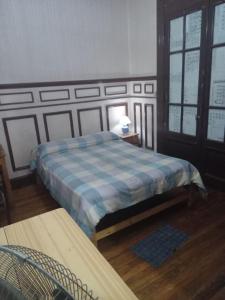 1 dormitorio con 2 camas y manta a cuadros en Habitac Indiv Casa de Familia, Flores en Buenos Aires