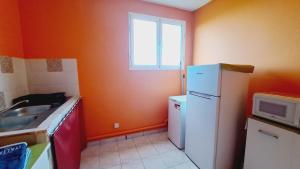une cuisine avec un réfrigérateur blanc et une fenêtre dans l'établissement La Baie de Coreil, à Bouillante 6 autres photos