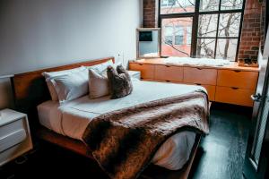 a bedroom with a bed with a blanket and a window at Massive Downtown Seattle Condo - Free Parking! in Seattle