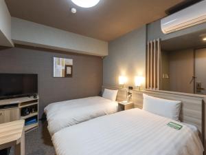 Voodi või voodid majutusasutuse Hotel Route Inn Numata toas