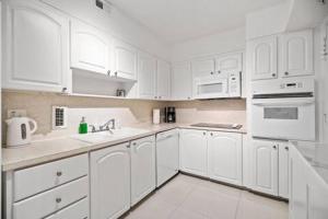 Great Apartment with beach access في هوليوود: مطبخ أبيض بدولاب أبيض وأجهزة بيضاء