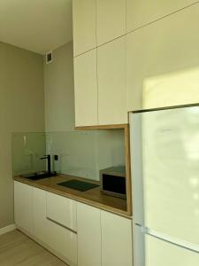 uma cozinha com armários brancos e um micro-ondas preto em Апартаменты в Aktau Riviera em Aktau