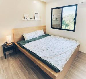 a large bed in a room with a window at Kiddie Hostel Unit30A-kids and pets friendly in Subic bay freeport zone in Kababae