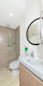 a bathroom with a toilet and a sink and a mirror at Apartamentos Montecarlo in Medellín