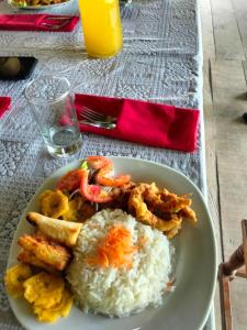 un plato blanco de comida con arroz y camarones en Amazon Jaguar Adventure & Lodge, en Iquitos