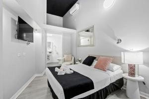 a white bedroom with a bed and a tv at Airport Hotel Sydney in Sydney