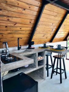 eine Außenküche mit einer Steintheke und einer Holzdecke in der Unterkunft Rancho Navarro in Pôrto de Pedras