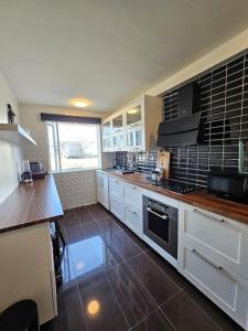 a kitchen with white cabinets and a stove top oven at Apartment near Reykjavik's heart in Reykjavík