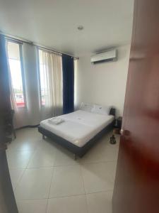 ein Schlafzimmer mit einem Bett in einem Zimmer mit einem Fenster in der Unterkunft Hotel Milenium in Yopal