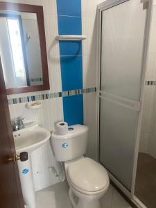 ein Badezimmer mit einem WC, einem Waschbecken und einem Spiegel in der Unterkunft Hotel Milenium in Yopal